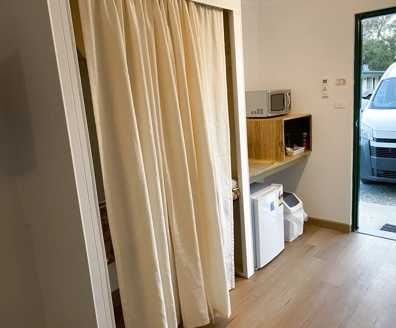 Kitchenette with a microwave, bench and bar fridge