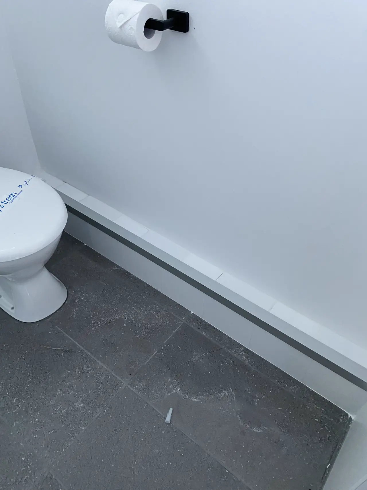 Toilet and tiled floor in one of the new bathrooms